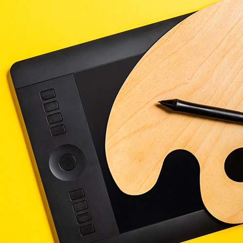 Ein Grafiktablet vor gelben Hintergrund, auf dem eine Farbpalette liegt.