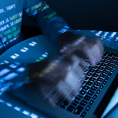 Ein Programmierer, der vor einem Laptop sitzt und eine Anwendung programmiert.