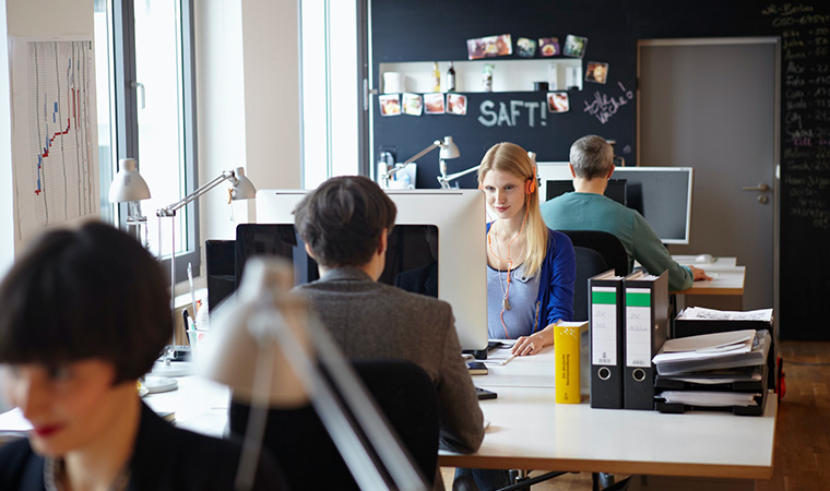 Webdesigner, die in einer Agentur an ihren Schreibtischen sitzen.